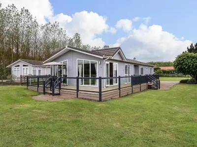 a house with a large deck in a yard at Owls Retreat, Lodge 11 in Aldeburgh