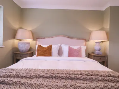 a bedroom with a white bed with two lamps at The Farmhouse in Clacton-on-Sea