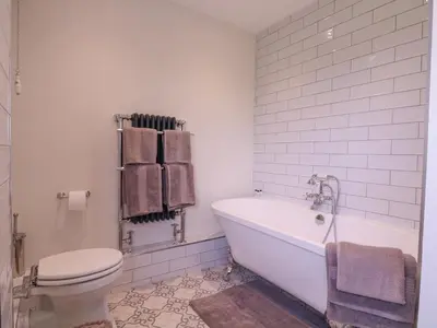 a white bathroom with a tub and a toilet at The Farmhouse in Clacton-on-Sea