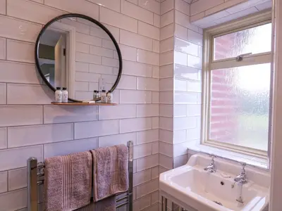 a bathroom with a sink and a mirror at The Farmhouse in Clacton-on-Sea