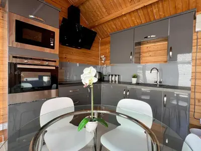 a kitchen with a glass table and white chairs at Duchess Lodge In Colchester 1BR,Couples, Contractors,Business Travellers, Free WIFI, Secure Parking in Colchester