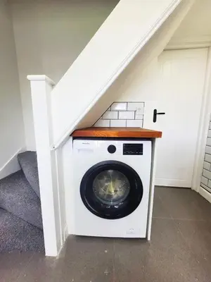 a washer and dryer in a room under a stairs at 3-Bed, Sleeps 6, 1 Bath, Parking, WiFi in Halstead
