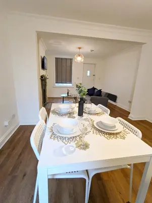 a white dining room table with plates and glasses on it at 3-Bed, Sleeps 6, 1 Bath, Parking, WiFi in Halstead