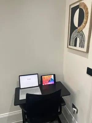 a desk with a laptop computer and a chair at Stylish Flat in London in Harold Wood