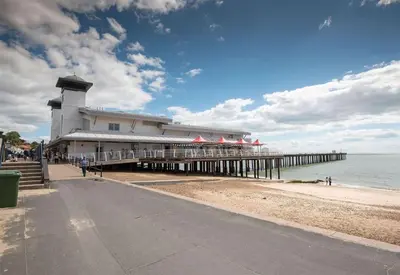 a pier with a building on the beach at Van-Tastic 6 berth static in Felixstowe