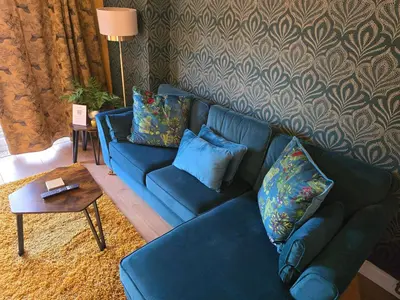 a blue couch in a living room with a table at Munnings Lodge Apartment in Mendham