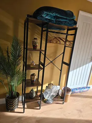 a black shelf with pots and a plant in a room at Munnings Lodge Apartment in Mendham