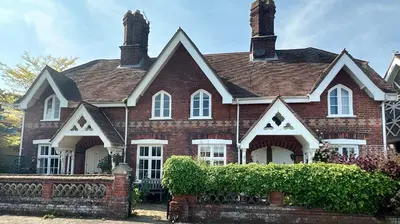 a red brick house with a fence in front of it at Cosy 2 bed cottage in beautiful Orford in Orford