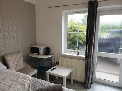 a bedroom with a bed and a window and a chair at Room Stay - Marks tey, Colchester, United Kingdom in Marks Tey