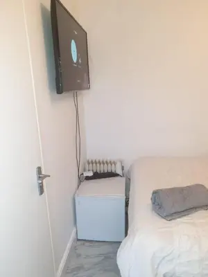 a bedroom with a bed and a tv on the wall at Room Stay - Marks tey, Colchester, United Kingdom in Marks Tey