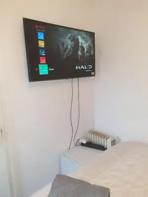a flat screen tv hanging on a wall at Room Stay - Marks tey, Colchester, United Kingdom in Marks Tey