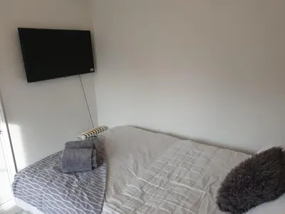 a bedroom with a bed with a flat screen tv at Room Stay - Marks tey, Colchester, United Kingdom in Marks Tey