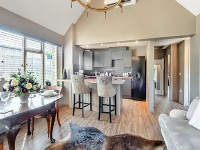a kitchen and living room with a table and chairs at Dovecote Cottage in Downham Market