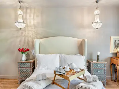 a bedroom with a bed with a tray of food on it at Dovecote Cottage in Downham Market