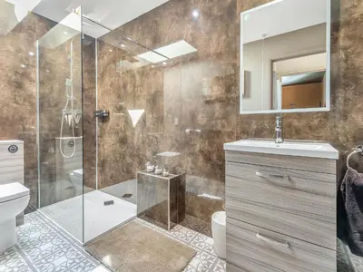 a bathroom with a shower and a toilet and a sink at Dovecote Cottage in Downham Market