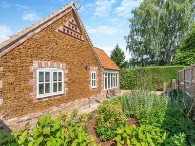 a brick house with a garden in front of it at Dovecote Cottage in Downham Market