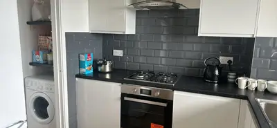 a kitchen with white cabinets and a stove top oven at Newmarket house in Newmarket