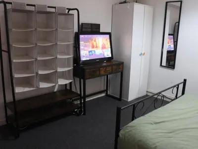 a bedroom with a television and a dresser with a bed at Newmarket house in Newmarket