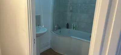 a bathroom with a bath tub and a sink at Newmarket house in Newmarket