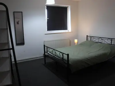 a bedroom with a bed and a window and a mirror at Newmarket house in Newmarket