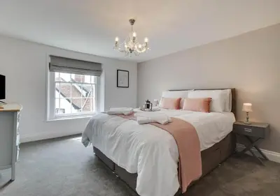 a bedroom with a large bed and a chandelier at The Keep - Framlingham in Framlingham