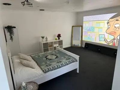 a bedroom with a bed and a large painting on the wall at Spacious private cinema guest house in Brentwood
