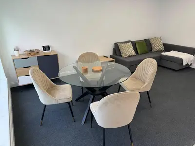 a living room with a glass table and chairs at Spacious private cinema guest house in Brentwood