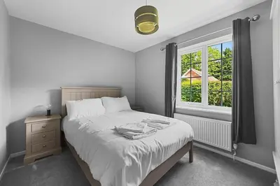 a bedroom with a large bed with a window at 10 Holly Close in Westley