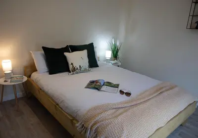 a bed with a book and pair of shoes on it at Luxury Chestnut Lodge with Hot Tub and Games Room in Toppesfield