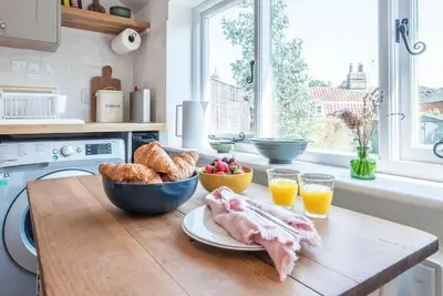 a kitchen with a table with bread and a bowl of food at 10 Angel Lane, Woodbridge in Woodbridge