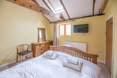 a bedroom with a large bed and a tv at Little Swattesfield, Eye in Eye