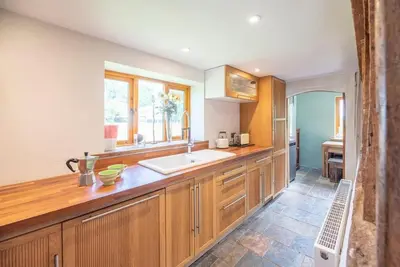 a kitchen with wooden cabinets and a sink at Little Swattesfield, Eye in Eye