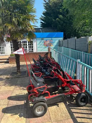a red horse drawn cart parked next to a fence at Highfield Grange Holiday Park in Clacton-on-Sea