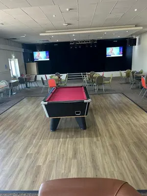 a pool table in the middle of a room with chairs at Highfield Grange Holiday Park in Clacton-on-Sea