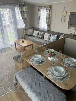 a living room with a table and a couch at Highfield Grange Holiday Park in Clacton-on-Sea