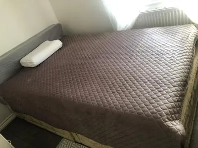 a bed in a small room with a brown mattress at Basildon, private room in a flat in Basildon