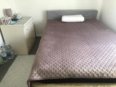 a large bed in a room with a dresser at Basildon, private room in a flat in Basildon
