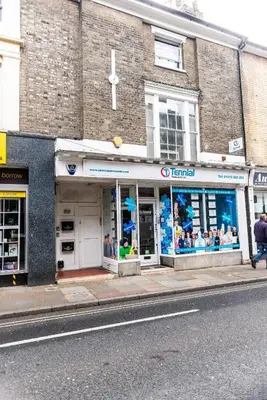 a store on a street with a cross in the window at Cozy 4-guest Getaway In The Heart Of Ipswich in Ipswich