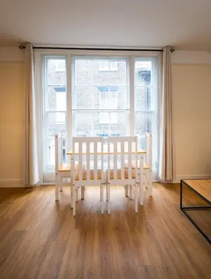a dining room with a table and chairs in front of a window at Cozy 4-guest Getaway In The Heart Of Ipswich in Ipswich