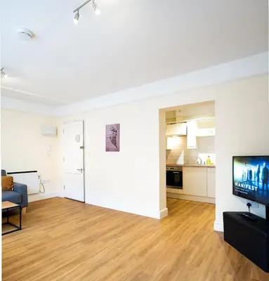 a living room with a flat screen tv and a couch at Cozy 4-guest Getaway In The Heart Of Ipswich in Ipswich