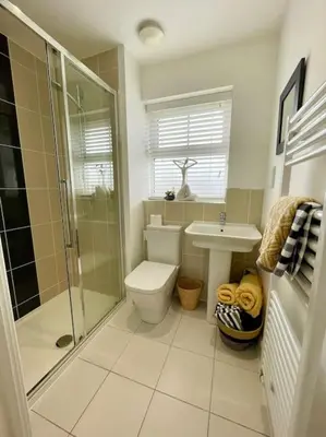 a bathroom with a shower and a toilet and a sink at Stunning Beachfront House in Felixstowe