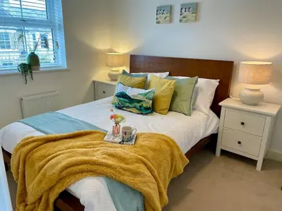 a bedroom with a bed with a blanket on it at Stunning Beachfront House in Felixstowe