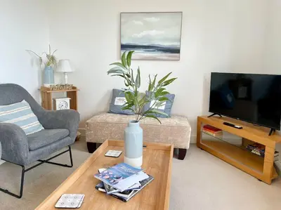 a living room with a vase on a coffee table at Stunning Beachfront House in Felixstowe