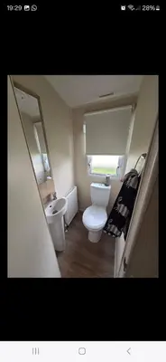 a small bathroom with a toilet and a sink at 8 berth caravan Martello Beach Clacton in Jaywick Sands