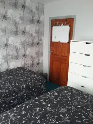a bedroom with a bed and a wall with trees at medium sized room in my bungalow in Great Clacton