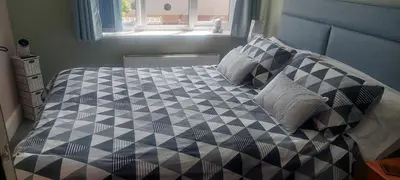 a bedroom with a bed with a black and white comforter at Felixstowe room lets in Felixstowe