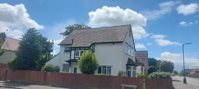 a white house with a fence in front of it at Felixstowe room lets in Felixstowe