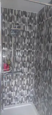 a bathroom with a black and white tiled wall at Felixstowe room lets in Felixstowe