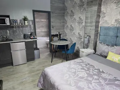 a bedroom with a bed and a table and a kitchen at Martello Bay Hotel in Clacton-on-Sea