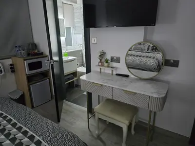 a bedroom with a dressing table and a mirror at Martello Bay Hotel in Clacton-on-Sea